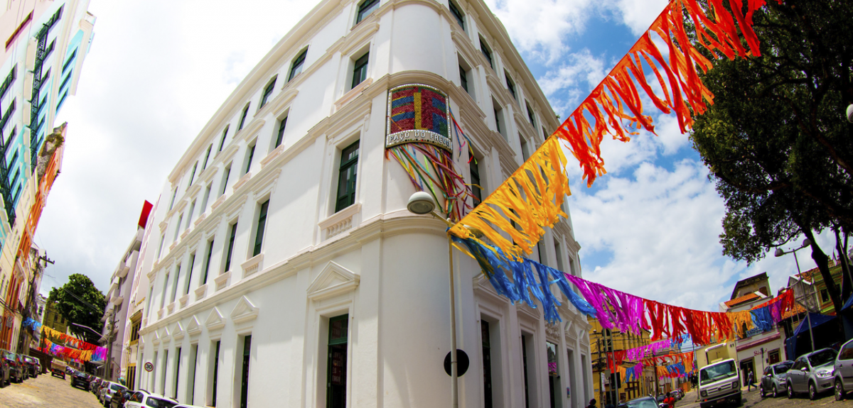 Fachada do centro cultural Paço do Frevo, em Recife. O prédio é branco com cordas coloridas penduradas em vermelho, amarelo, azul e violeta, que lembram o carnaval.